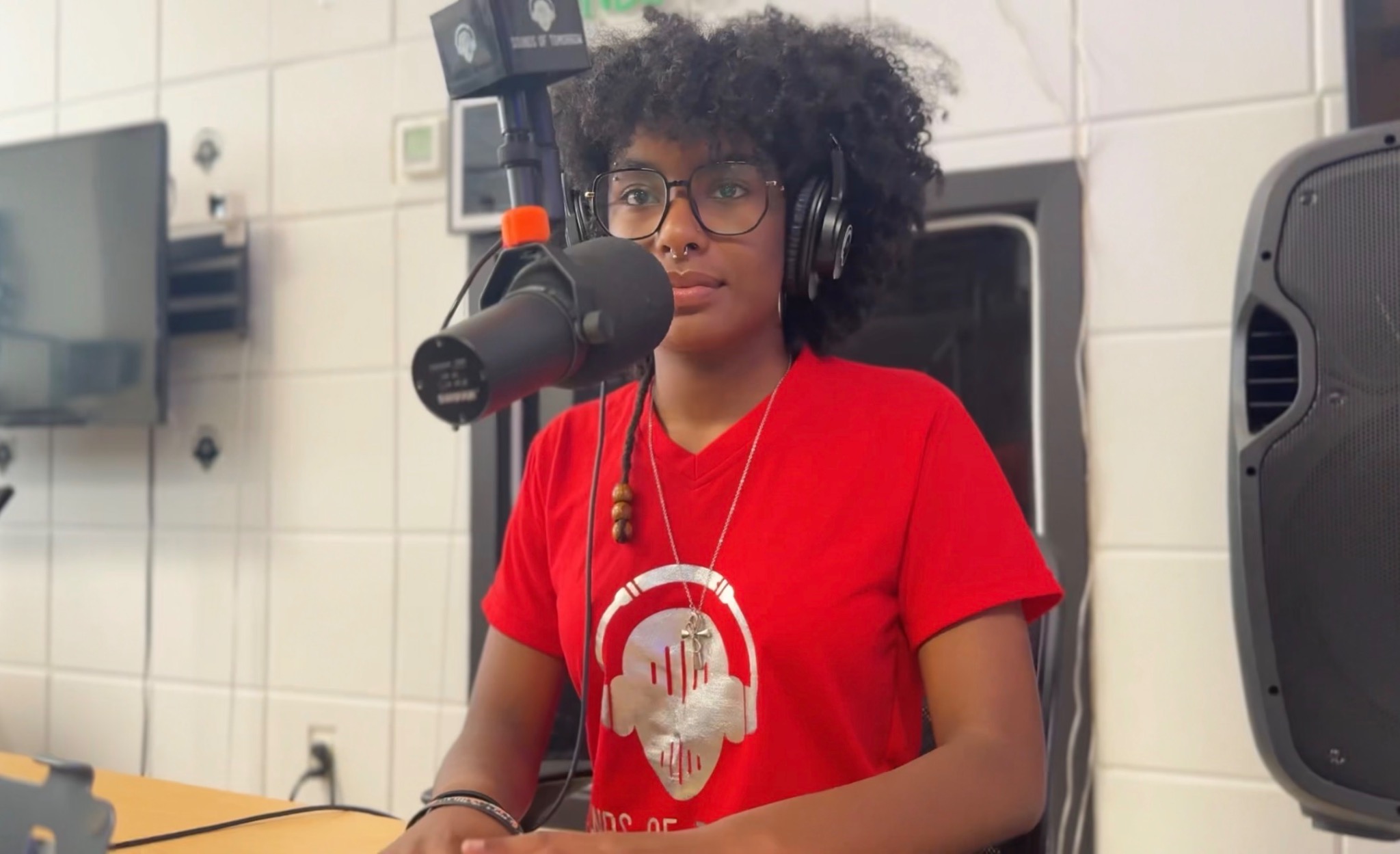 Podcast participant wearing Sounds of Tomorrow merchandise at a studio microphone